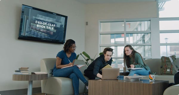 Students chatting with Ditto digital signage running on a TV behind them