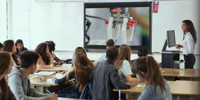 Students in a classroom learning about robotics by using screen mirroring tech as a document camera