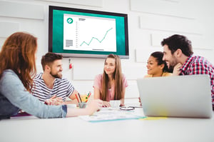 People collaborating together while wirelessly sharing a computer screen to a larger display