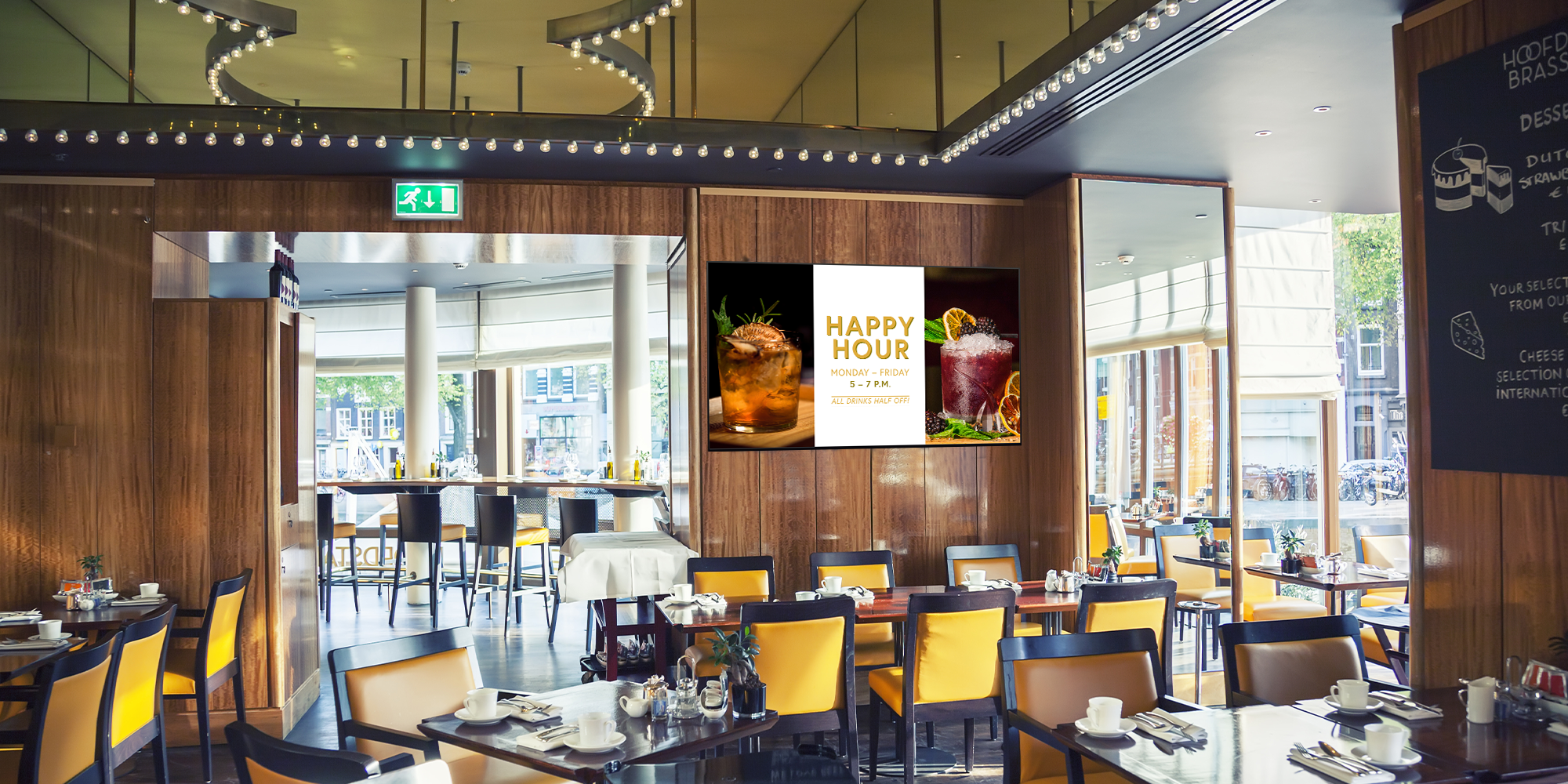 Digital signage on a restaurant TV promoting happy hour